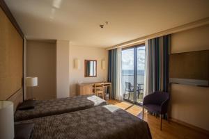 Postel nebo postele na pokoji v ubytování Antillia Hotel