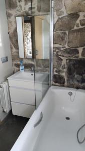 a bathroom with a tub and a sink and a mirror at Casa Rural Elvira Ribeira Sacra in Asma