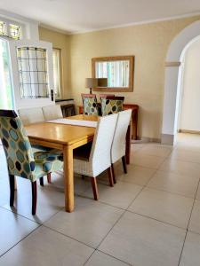a dining room with a wooden table and chairs at Caribbean Estates 31 Montego Bay in Port Edward