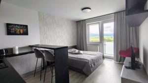 a bedroom with a bed and a table and a window at Sunset Studio Apartment in Poprad