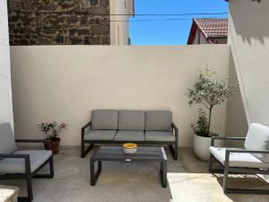 a patio with a couch and a table and chairs at Un havre de paix en plein coeur de ville près Chu in Clermont-Ferrand