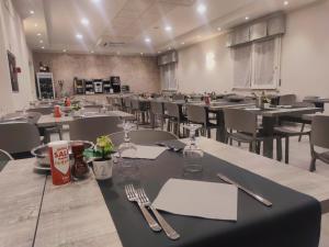 una sala da pranzo con tavoli, sedie e utensili di Hotel Bergamo a Rimini