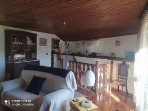 a living room with a white couch and a wooden ceiling at ABRIGO DO CABECINHO - SERRA DA ESTRELA in Cortes do Meio