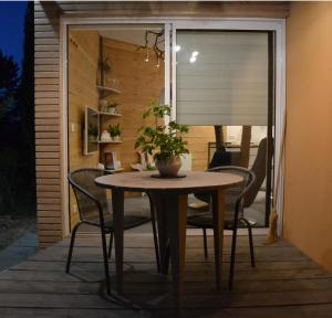 una mesa con sillas y una planta en un patio en Le gîte du petit branché, en Mazan