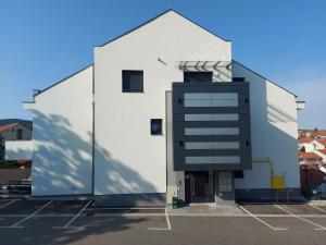 a large white building with a glass facade at Tri S LUX in Arandjelovac
