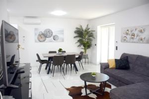 ein Wohnzimmer mit Sofa und Tisch in der Unterkunft Apartmani Magić in Jalžabet