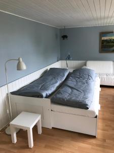 a bedroom with a bed and a table and a lamp at Sommerhus på Mors in Øster Assels