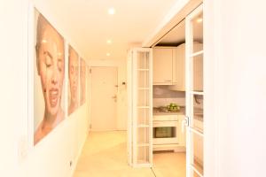a kitchen with white cabinets and a painting on the wall at Lisbon Swimming pool apartment with private parking in Lisbon