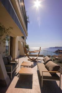 a balcony with couches and a hammock on a building at Vertmont Villa in Sveti Stefan