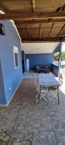a patio with a table and a blue wall at Ouranoupolis View Point in Ouranoupoli