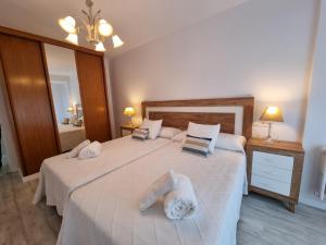 sypialnia z dużym łóżkiem z białą pościelą i poduszkami w obiekcie 143A Moderno, céntrico, 3 habitaciones w mieście Gijón