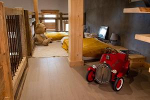 ein Schlafzimmer mit einem Teddybär und einem roten Spielzeugauto in der Unterkunft Le Chalet de Vincent in Cordon