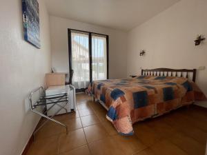 a bedroom with a bed and a chair and a window at Motel Esterel in Mandelieu-La Napoule