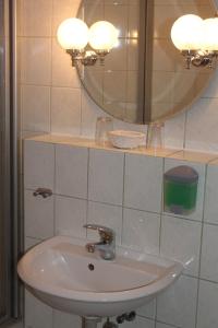 uma casa de banho com um lavatório branco e um espelho. em Ammerscher Bahnhof em Mühlhausen