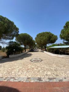 uma passarela num parque com árvores ao fundo em La Campanella em Manduria