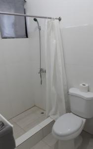 y baño blanco con aseo y ducha. en Vilaa Colonial Suite N 7, Basic exterior, en Río San Juan