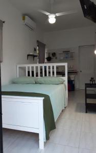 1 dormitorio con cama blanca y cabecero blanco en Vilaa Colonial Suite N 7, Basic exterior, en Río San Juan