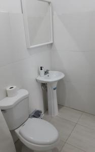 Baño blanco con aseo y lavamanos en Vilaa Colonial Suite N 7, Basic exterior, en Río San Juan