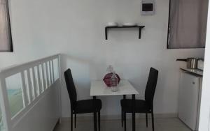 mały biały stół z czarnymi krzesłami w pokoju w obiekcie Vilaa Colonial Suite N 7, Basic exterior w mieście Río San Juan