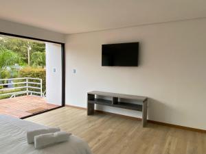 a bedroom with a bed and a television on the wall at Harmony Glamping in San Luis de Gaceno