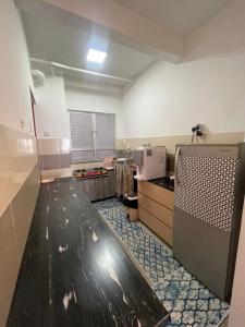 a large kitchen with a counter in a room at Apartment Ladang Tok Pelam Sea View ,Berdekatan Pantai Batu Burok,KTCC,Hospital,Drawbridge by Homestay Seri Terengganu in Kuala Terengganu +3 photos