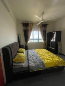 a bedroom with a bed with yellow sheets and a window at Apartment Ladang Tok Pelam Sea View ,Berdekatan Pantai Batu Burok,KTCC,Hospital,Drawbridge by Homestay Seri Terengganu in Kuala Terengganu