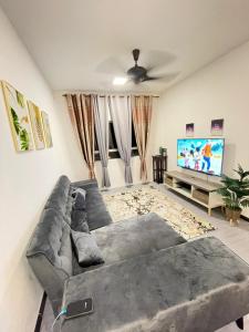 a living room with a large couch and a flat screen tv at Apartment Ladang Tok Pelam Sea View ,Berdekatan Pantai Batu Burok,KTCC,Hospital,Drawbridge by Homestay Seri Terengganu in Kuala Terengganu