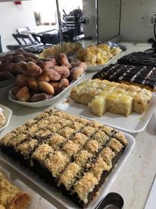 um buffet de diferentes tipos de sobremesas e produtos de pastelaria em Pousada Casa Amarela Brisa Parque em Penha