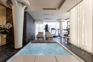 Luxury B&B Villetta Carra City - Gallipoli في غالّيبولي: صالة رياضية مع مسبح وسط الغرفة