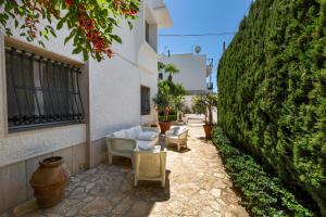 a patio with white furniture and a large green hedge at Luxury B&B Villetta Carra City - Gallipoli in Gallipoli +25 photos
