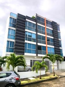 a car parked in front of a building with palm trees at Navona Towers Amplio Apart, Dos Noches minimo, para 4 personas lo mejor de Panamá in Panama City