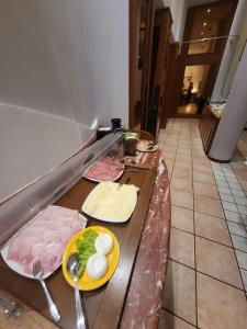 a buffet line with meat and eggs on it at Hotel Norden Palace in Aosta