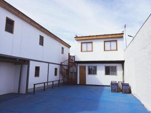 a large white building with a staircase in front of it at HOSTAL SOL ATACAMA -CALDERA in Caldera