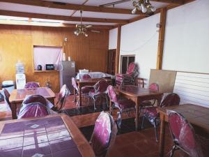 a dining room with tables and chairs and a refrigerator at HOSTAL SOL ATACAMA -CALDERA in Caldera