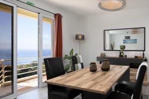 a dining room with a table and a view of the ocean at UP THE HILL, Conforto e bem estar in Ponta do Sol