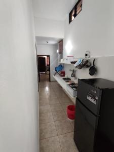 cocina con nevera negra y suelo de baldosa en Villa Colonial suite n 3 familiar, en Río San Juan