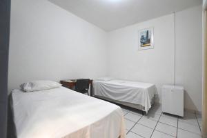 a hospital room with two beds and a mirror at Hotel Tapajós in Cuiabá