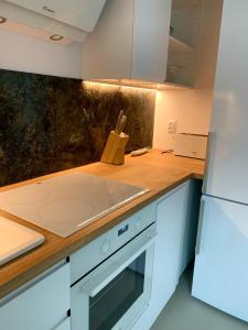 une cuisine avec des armoires blanches et un comptoir dans l'établissement Baltica Heaven - Apartament dwupoziomowy przy plaży, à Rogowo