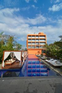 a hotel with a swimming pool in front of a building at SinQ Party Hotel - No Male Stags Allowed in Candolim