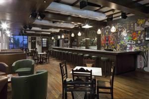 a restaurant with a bar with tables and chairs at SinQ Party Hotel - No Male Stags Allowed in Candolim