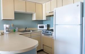 a kitchen with a white refrigerator and a sink at Wave Rider Resort in Myrtle Beach