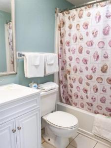 a bathroom with a toilet and a shower curtain at Wave Rider Resort in Myrtle Beach