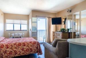 a bedroom with a bed and a couch and a television at Wave Rider Resort in Myrtle Beach