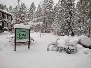 a sign is covered in snow next to a sign at Villa Karllösa Bed and Breakfast in Målilla