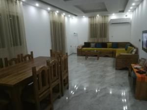 a living room with a couch and a table at Belle Villa Proche Marina in Houmt Souk