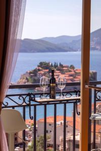 a bottle of wine and two wine glasses on a balcony at Vertmont Villa in Sveti Stefan