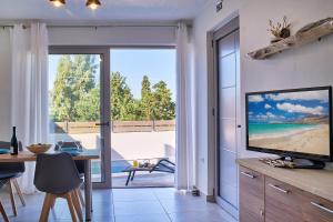 a living room with a television and a view of the beach at Villa Vagelia in  Episkopi (Chania)