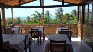 a restaurant with tables and chairs and a view of the ocean at Bela Vista in Canoa Quebrada
