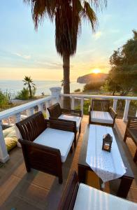 un patio con sillas, mesas y el océano en ZBB Stylish Villa & Bungalows, en Alanya