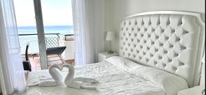 a white bedroom with two towels on a bed at MI CAPRICHO C16 Beachfront Apartment in Mijas Costa +53 photos